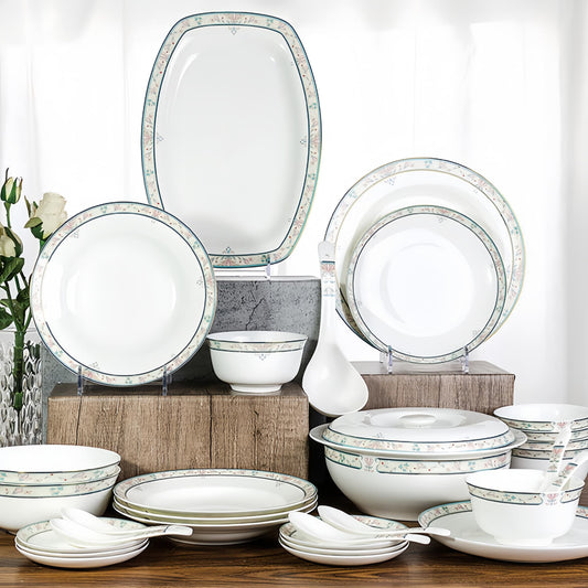 Set of white dinnerware with decorative green rim on a wooden table. YUNGPING Blossom Spring Fine Bone China Dinnerware Set, 30-Piece, styled on an elegant dining table for formal hosting and special occasions.