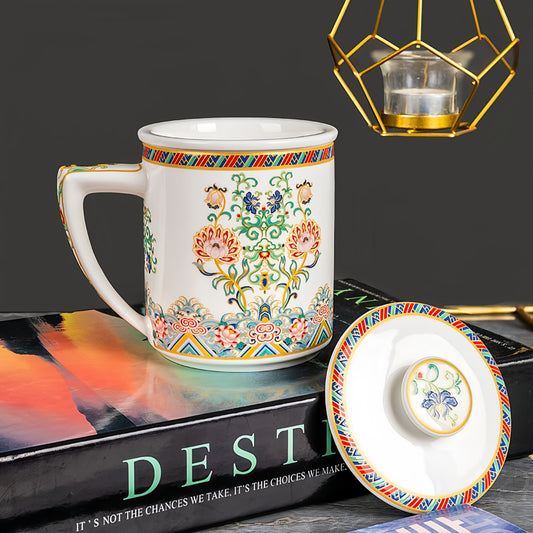 Decorative mug with intricate patterns on a book,  YUNGPING Brocade Floral Cluster Fine Bone China Infuser Tea Mug, 3-Piece, styled for a casual afternoon tea.