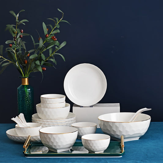 Set of white bone china dishes with gold accents on a blue surface against a dark background, YUNGPING Crystal Cube Fine Bone China Dinnerware Set, 22-Piece, styled on an elegant dining table for formal hosting and special occasions.
