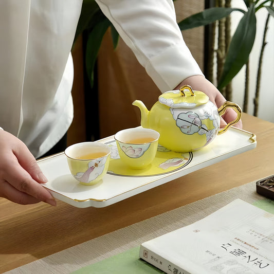 Yellow teapot and cups on a tray held by a person, YUNGPING Lotus Whisper Fine Bone China Tea Set