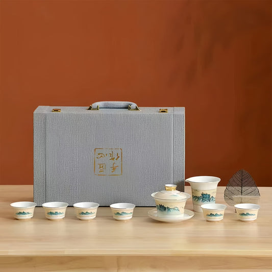 Tea set with cups and a teapot in front of a gray box on a wooden table. YUNGPING Poetic Hills Fine Bone China Tea Set