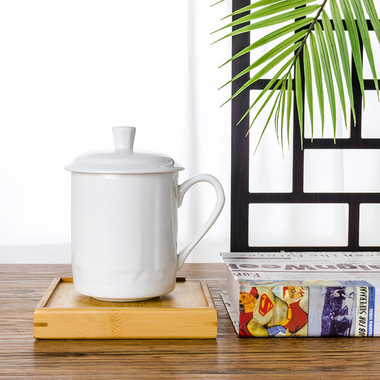 YUNGPING scholar White bne china mug with a lid on a wooden coaster next to a book and plant