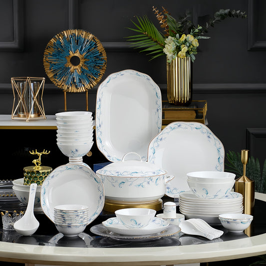 Dining table set with white dishes featuring blue floral patterns, against a dark wall. YUNGPING Verdant Vines Fine Bone China Dinnerware Set, 50-Piece, styled on an elegant dining table for formal hosting and special occasions.